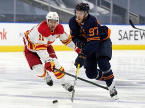 The Edmonton Oilers' Connor McDavid (97) battles the Calgary Flames' Mikael Backlund (11) at Rogers Place, in Edmonton on Thursday, April 29, 2021.