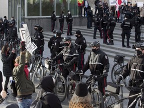 Police line up between anti-mask protestors and counter-protesters at the Alberta legislature in February.