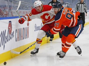 Calgary Flames forward Joakim Nordstrom (20) and Edmonton Oilers forward Connor McDavid (97) chase a loose puck during the first period at Rogers Place on April 2, 2021.
