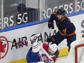 Edmonton Oilers Kris Russell (4) upends Montreal Canadiens Paul Byron (41) during first period NHL action on Wednesday,April 21, 2021 in Edmonton.