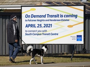 A man and his dog walk past a sign in southwest Edmonton on Friday April 23, 2021. Edmonton Transit System schedules and stops will change starting Sunday April 25, 2021.