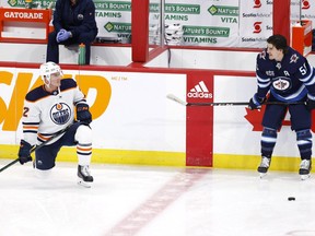 Edmonton Oilers defenseman Tyson Barrie (22) talks with Winnipeg Jets center Mark Scheifele (55) in warm up at Bell MTS Place in Winnipeg on April 26, 2021.