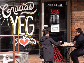 A thankful message is seen on the window of Huma Mexican restaurant in Edmonton while diners enjoy a warm day on a patio on Thursday, April 29, 2021. COVID-19 restrictions mean that dining inside restaurants is currently banned. Photo by Ian Kucerak