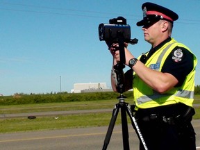 A police officer uses laser radar to catch speeders.