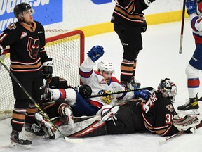 The Edmonton Oil Kings and Calgary Hitmen have a pileup in the crease during game at Seven Chiefs Sportsplex in Calgary on March 27, 2021.