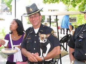 Retired Geauga County Sheriff Dan McClelland, centre, is pictured with K-9 Midge in this photo posted on the Twitter account of Geauga County Sheriff's Office.