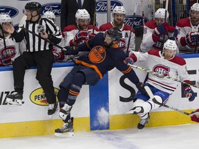 Edmonton Oilers Jujhar Khaira (16) is pulled down by Montreal Canadiens Brett Kulak (77) during first period NHL action on Monday, April 19, 2021 in Edmonton.