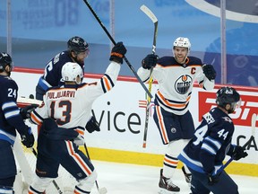 Edmonton Oilers centre Connor McDavid (right) celebrates his goal against the Winnipeg Jets with teammate Jesse Puljujarvi in Winnipeg on Mon., April 26, 2021.