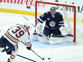 Edmonton Oilers forward Alex Chiasson is stopped by Winnipeg Jets goaltender Connor Hellebuyck in Winnipeg on April 26, 2021.