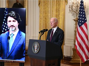 Prime Minister Justin Trudeau appears on- screen as U.S. President Joe Biden speaks to the media in February after the two held a virtual bilateral meeting. The Americans have hit their stride in battling COVID-19; Canada's approach lacks focus and coherence.