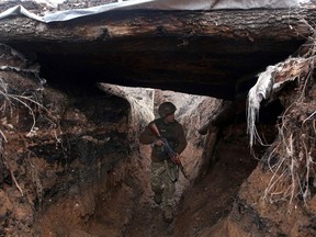 TOPSHOT - A Ukrainian serviceman patrols along a position at the front line with Russia-backed separatists not far Avdiivka, Donetsk region on April 5, 2021. (Photo by STR / AFP)