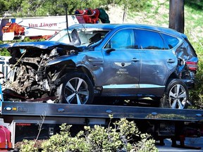 (FILES) In this file photo a tow truck recovers the vehicle driven by golfer Tiger Woods in Rancho Palos Verdes, California, on February 23, 2021, after a rollover accident. - Tiger Woods was driving at nearly double the 45 mph speed limit when he crashed in California in February, Los Angeles County's sheriff said on April 7, 2021. Woods's SUV flew off the road at up to 87 miles (140 kilometers) an hour and flipped several times during the accident in Ranchos Palos Verdes, leaving the 45-year-old, 15-time major champion with a shattered right leg. (Photo by Frederic J. BROWN / AFP)