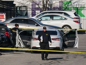 Crime scene investigators walk through the parking lot of the mass shooting site at a FedEx facility in Indianapolis, Indiana, on April 16, 2021. - A gunman has killed at least eight people at the facility before turning the gun on himself in the latest in a string of mass shootings in the country, authorities said. The incident came a week after President Joe Biden branded US gun violence an "epidemic" and an "international embarrassment" as he waded into the tense debate over gun control, a powerful political issue in the US. (Photo by Jeff Dean / AFP)