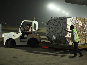 In this handout photograph taken taken on April 27, 2021 and released by the Foreign, Commonwealth and Development Office shows ground staff unloading medical aid from an aircart sent from the United Kingdom upon its arrival at an airport, in New Delhi. (Photo by - / Foreign, Commonwealth & Development Office / AFP) / RESTRICTED TO EDITORIAL USE - MANDATORY CREDIT "AFP PHOTO /Foreign, Commonwealth & Development Office " - NO MARKETING - NO ADVERTISING CAMPAIGNS - DISTRIBUTED AS A SERVICE TO CLIENTS