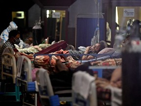 TOPSHOT - Covid-19 coronavirus positive patients are seen inside a banquet hall temporarily converted into a covid care centre in New Delhi on April 29, 2021.