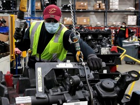 FILE PHOTO: A Dana Inc assembly technician wears a face mask as he works to assemble axles for automakers, as the auto industry begins reopening amid the coronavirus disease (COVID-19) outbreak, at the Dana plant in Toledo, Ohio,U.S., May 18, 2020. REUTERS/Rebecca Cook/File Photo ORG XMIT: FW1