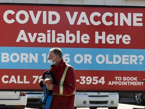 A pedestrian walks past a sign advertising COVID-19 vaccines at the Shoppers Drug Mart, 8065 104 St., in Edmonton Wednesday April 21, 2021. Photo by David Bloom