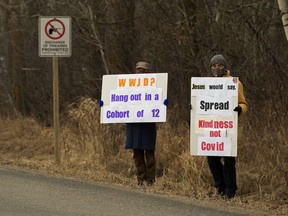 Two people protest outside GraceLife Church's in-person Easter Sunday Service, in Edmonton Sunday April 4, 2021.