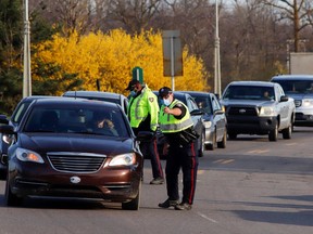 Motorists are stopped at a police checkpoint after new coronavirus disease (COVID-19) restrictions came into effect, limiting travel into the province of Ontario, in Ottawa, Ontario, Canada April 19, 2021.