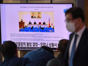 People watch a television screen showing a news report about North Korea's decision not to participate in the Tokyo Olympics due to the Covid-19 pandemic, at a railway station in Seoul on April 6, 2021.