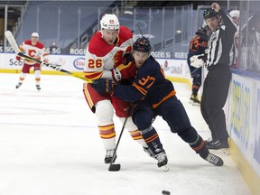 The Edmonton Oilers' Connor McDavid (97) battles the Calgary Flames' Michael Stone (26) during first period NHL action at Rogers Place, in Edmonton Thursday April 29, 2021.