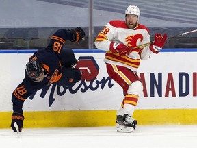 The Edmonton Oilers' James Neal (18) is sent flying by the Calgary Flames' Nikita Nesterov (89) during first period NHL action at Rogers Place, in Edmonton Thursday April 29, 2021.