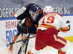 The Edmonton Oilers' goalie Mike Smith (41) battles the Calgary Flames' Matthew Tkachuk (19) behind the net during second period NHL action at Rogers Place, in Edmonton Thursday April 29, 2021.