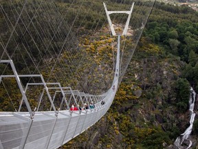 People walk on the world's longest pedestrian suspension bridge '516 Arouca', now open for local residents in Arouca, Portugal, April 29, 2021. REUTERS/Violeta Santos Moura ORG XMIT: GGG-VSM106