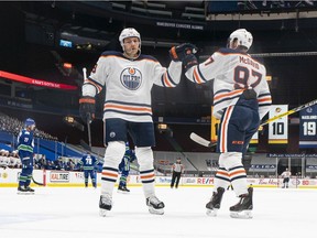 Connor McDavid (97) of the Edmonton Oilers is congratulated by teammate Leon Draisaitl (29) after scoring a goal against the Vancouver Canucks at Rogers Arena on May 3, 2021, in Vancouver.
