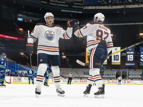 Connor McDavid (97) de los Edmonton Oilers es felicitado por su compañero de equipo Leon Draisaitl (29) después de marcar un gol contra los Vancouver Canucks en el Rogers Arena el 3 de mayo de 2021 en Vancouver.