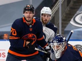 Goaltender Mike Smith (41) and Dmitry Kulikov (70) of the Edmonton Oilers defend their net in front of Pierre-Luc Dubois (13) of the Winnipeg Jets during Game 2 of their 2021 Stanley Cup playoff series at Rogers Place on Friday, May 21, 2021, in Edmonton.
