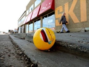 A pedestrian makes their way past an inflatable ball, with a crying laughing emoji graphic, laying in the gutter along 79 Avenue near 105 Street, in Edmonton Wednesday May 12, 2021. Photo by David Bloom