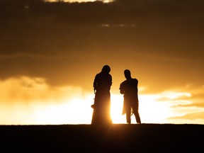 A couple dressed in fine clothing takes photos at sunset on Eid al-Fitr at the hill at the Walterdale Bridge in Edmonton, on Thursday, May 13, 2021. Photo by Ian Kucerak