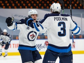 Winnipeg Jets’ Tucker Poolman (3) celebrates a goal with teammates on Edmonton Oilers’ goaltender Mike Smith (41) during the second period of NHL North Division playoff action at Rogers Place in Edmonton, on Wednesday, May 19, 2021.