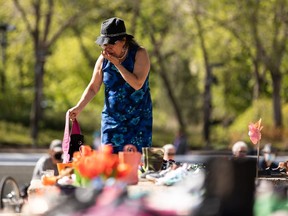 Elder Kathy Hamelin reacts to seeing children's shoes left in memory of 215 children whose remains were found in unmarked graves at the site of the Kamloops Indian Residential School during a vigil at the "Service through Christ" statue at the Alberta Legislature in Edmonton on May 30, 2021.