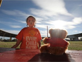 Kenai Ermineskin, 2, and his grandmother Leonora Baptiste (not pictured) look at the 215 bears set up in honour of the 215 children found in a mass grave at the Kamloops Residential School, during a memorial event on the Maskwacis First Nation in Alberta, Monday May 31, 2021. Photo by David Bloom