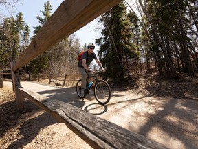 A cyclist rides down a hill from Forest Heights Park in the river valley in Edmonton, on Friday, April 30, 2021. Photo by Ian Kucerak