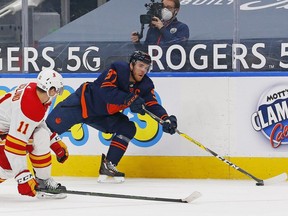 Edmonton Oilers forward Connor McDavid (97) tries to make a pass in front on Calgary Flames forward Michael Backlund (11) during the third period at Rogers Place on May 1, 2021.