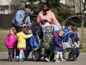 Two daycare workers take a group of children out for a walk in west Edmonton on Thursday May 6, 2021.
