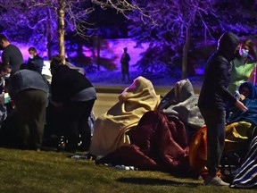 Hundreds of seniors are lined up outside wrapped in blankets as a massive fire burns at the Citadel Mews West seniors home in St. Albert, May 6, 2021.