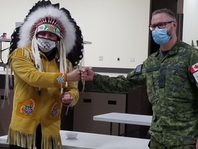Onekenew Cree Nation Chief Christian Sinclair, left, receives a token of friendship from Master Warrant Officer Tim Steakhouse of 1 Field Ambulance following a smudging ceremony.