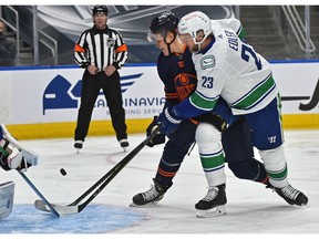 Edmonton Oilers Jesse Puljujarvi (13) couldn't get a handle on the puck being tied up by Vancouver Canucks Alexander Edler (23) during NHL action at Rogers Place in Edmonton, May 15, 2021.