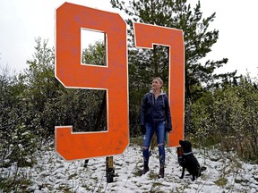 Michelle Dall'Acqua and her dog Pepper stop to view a 97 sign that someone erected just off Lansdowne Drive near 47 Avenue in Edmonton on Wednesday May 19, 2021. The sign can be seen when driving east on Whitemud Drive, just west of 122 Street. Edmonton Oilers captain Connor McDavid (#97) and team start their NHL Stanley Cup hockey playoff series against the Winnipeg Jets on May 19, 2021.