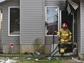 Fire investigators on the scene of a house fire along 35 St. near 18A Ave. which has sent a number of children and an adult to hospital in Edmonton, May 19, 2021.
