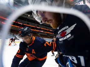 Edmonton Oilers' Darnell Nurse (25) checks Winnipeg Jets' Kyle Connor (81) during the second period of NHL North Division playoff action at Rogers Place in Edmonton, on Wednesday, May 19, 2021.