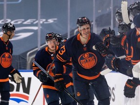 Edmonton Oilers' Jesse Puljujarvi (13) celebrates his goal on Winnipeg Jets' goaltender Connor Hellebuyck (37) with teammates during the second period of NHL North Division playoff action at Rogers Place in Edmonton, on Wednesday, May 19, 2021.