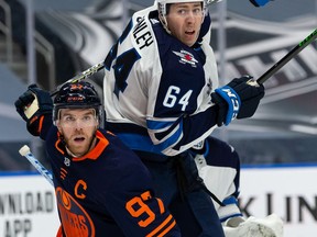 Edmonton Oilers' Connor McDavid (97) battles Winnipeg Jets' Logan Stanley (64) during the third period of NHL North Division playoff action at Rogers Place in Edmonton, on Wednesday, May 19, 2021.