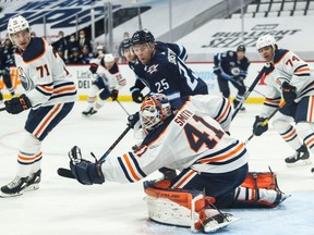 Edmonton Oilers goalie Mike Smith (41) reaches for the puck with Winnipeg Jets forward Paul Stastny (25) looking for a rebound during the second period in game four of the first round of the 2021 Stanley Cup Playoffs at Bell MTS Place.