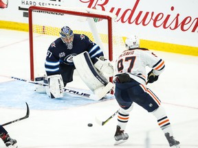 Edmonton Oilers forward Connor McDavid (97) skates in on Winnipeg Jets goalie Connor Hellebuyck (37)) during the third period in game four of the first round of the 2021 Stanley Cup Playoffs at Bell MTS Place.