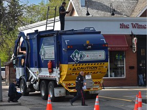 Police investigate after a woman was found in this garbage truck and a man was injured in a back alley off 102 Avenue near 124 Street in Edmonton on Wednesday, May 26, 2021.